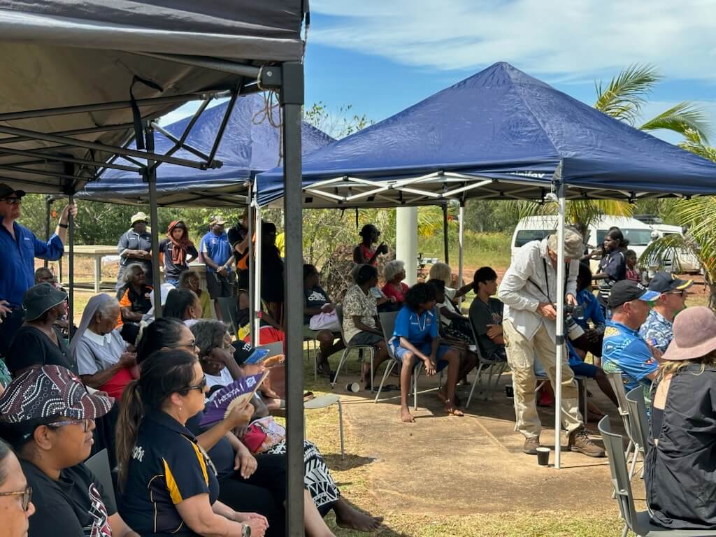 Crowd sitting under shade 