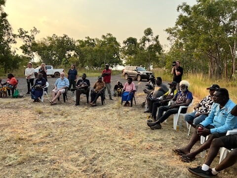 Crowd sitting in chairs in a circle talking in Wadeye 