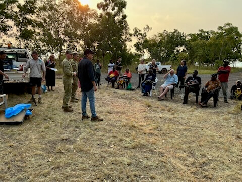 Crowd sitting in chairs in a circle talking in Wadeye 