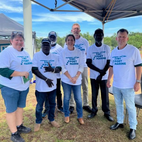 Group of people smiling, wearing "Tiwi Port Marine" shirts