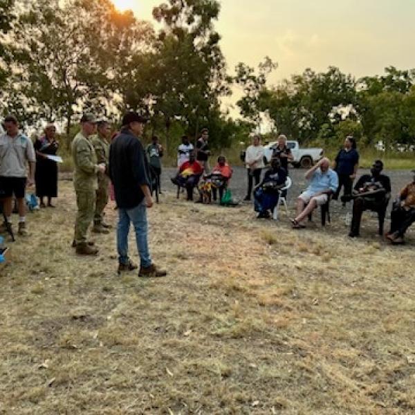 Crowd sitting in chairs in a circle talking in Wadeye 